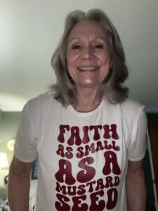 A woman with a shirt that says Faith As Small As A Mustard Seed