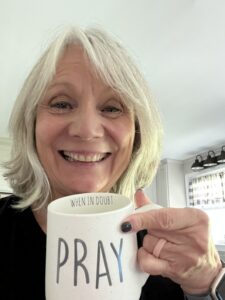 Woman holding a mug that says Pray